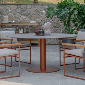 Superior Atmosphera Arena round table with smooth medium gray gres and reddish-brown cylindrical base construction