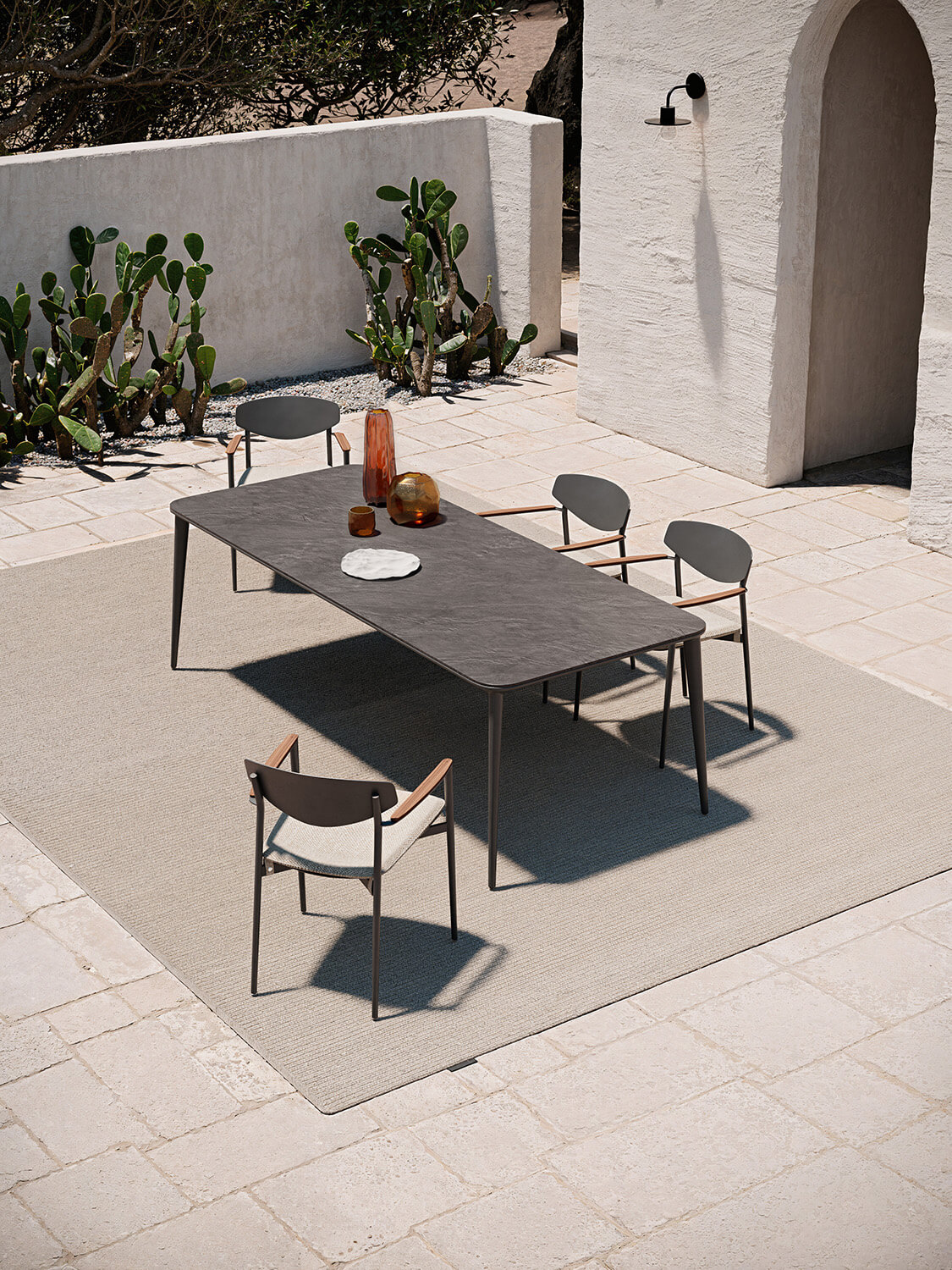 Elegant Atmosphera Origami armchair with a matte dark aluminum shell and warm natural teak armrests