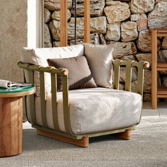 Elegant Atmosphera Portofino lounge chair with curved silhouette and natural teak details in muted olive green and neutral beige