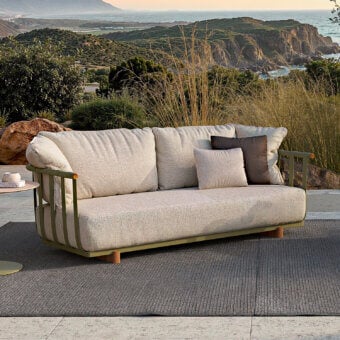 Sophisticated Atmosphera Portofino sofa with muted olive-green aluminum and warm teak details, crafted with light beige textured cushions