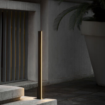Elegant Contardi Fly Outdoor floor lamp in dark gray matte metal emits a warm yellow glow with architectural clarity