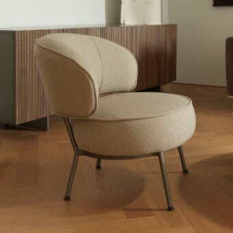 Elegant Horm Vendome lounge chair with muted beige textile upholstery and sleek dark gray metal base