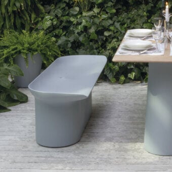 Sophisticated Serralunga Luba bench crafted in muted grey-blue LLDPE plastic with a suede-like finish and organically curved silhouette