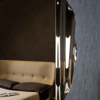 Distinguished Tonin Casa Anemos mirror with a highly reflective glass surface and dark synthetic backing in a satin tone finish