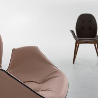 Exceptional Tonin Casa Sorrento armchair with curved form and muted brown leather upholstery in warm oak finish