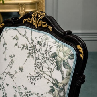 Distinctive Bellotti Ezio dining chair with black lacquered tempera brush finish, aged gold accents, cream upholstered backrest botanical print muted green grey, light blue braided trim, carved foliate silhouette