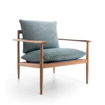 Sleek Giorgetti Kumiki lounge chair with blue and white geometric pattern textile cushions in solid wood natural matte finish
