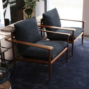 Elegant Giorgetti lounge chair with canaletto walnut frame satin finish and navy blue cushions padded with goose feathers