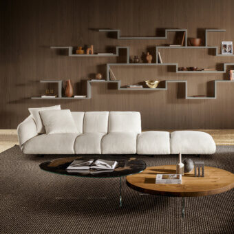 Elegant sectional with textured nubby off‑white finish, soft curved lines, armless deep seating, seamless lounge extension, dark feet on brown rug