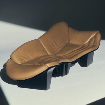 Sleek Visionnaire Blob Sofa sculptural chair in warm tan leather and matte black synthetic base with high-gloss lacquer