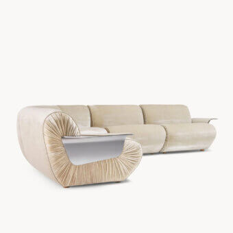 Luxury sectional with cream‑washed velvet‑like upholstery, silver‑toned metal inserts, leather‑padded wing‑shaped armrest, and soft sheen