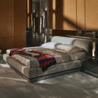 Prestige Visionnaire Prelude bed with polished veined marble base, glossy marble plinth, and gentle greige upholstered headboard