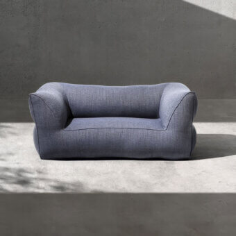 Premium Gart Puffone sofa with muted blue-grey outdoor fabric and matte grainy texture, low-profile wide silhouette