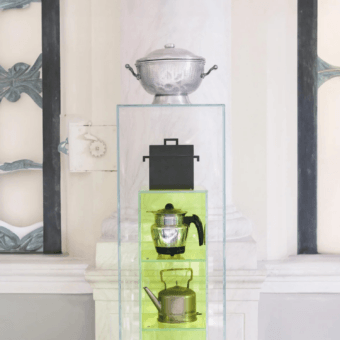 Elite Glas Italia display case with crystal-clear translucent yellowish-green mirror-polished stainless steel base