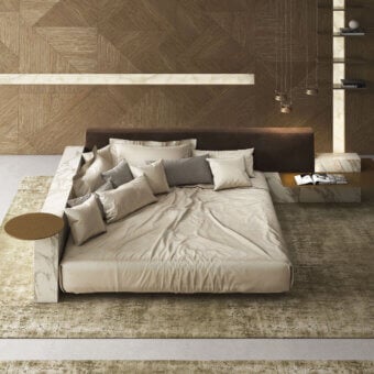 Elegant Laurameroni Symphony Bed with ceramic‑clad structure, black aniline‑dyed wood base, padded velvet headboard, white marble‑like surround with grey veining, beige and off‑white bedding, and natural brown wood side table