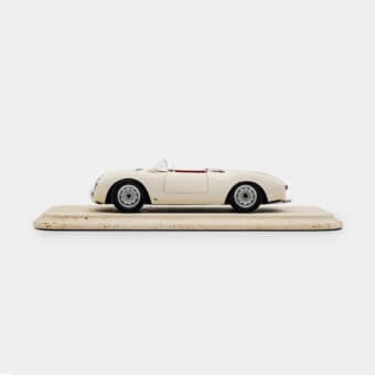 Sophisticated Vèlle Milano Porsche 550A Spyder model in glossy off-white metal with red interior and natural marble base