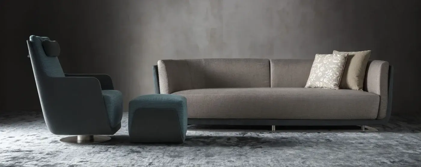 Superior OAK New York lounge chair upholstered in textured blue-gray textile with a dark swiveling metallic base and matching ottoman