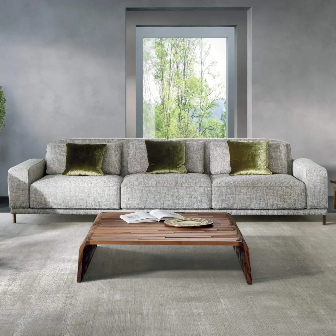 Distinguished Pacini & Cappellini Costanza sofa with light textured fabric upholstery and olive green velvet cushions built on dark wood feet