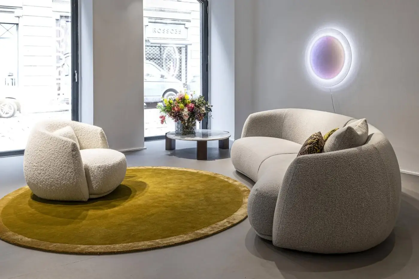Lavish Moroso Pacific lounge chair with enveloping rounded form upholstered in textured off-white fabric and black polypropylene glides