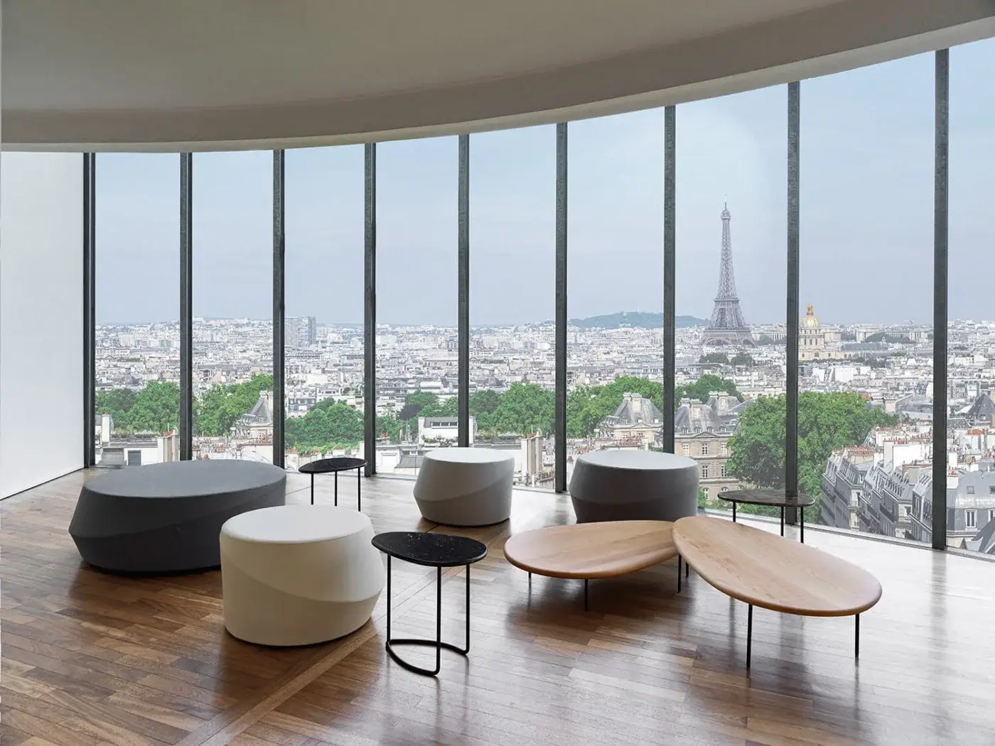 Elegant Casamania Giro ottoman presents an elongated oval shape fully upholstered in premium fabric with a smooth matte light-brown wood tabletop and dark metal legs