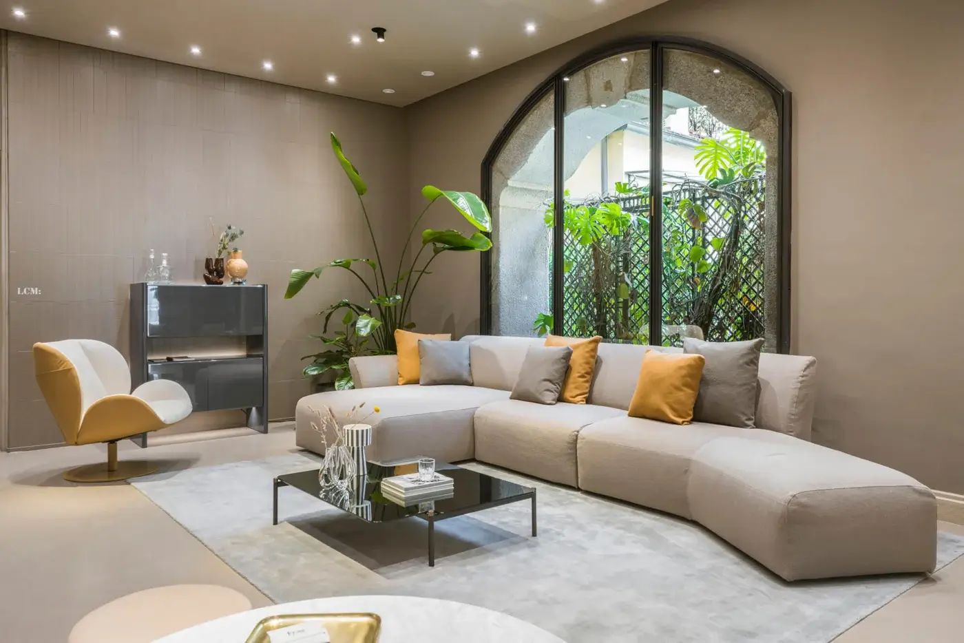 Superior Frag Hug sectional with geometric shapes and welcoming volumes upholstered in light beige textile with gray and mustard accents