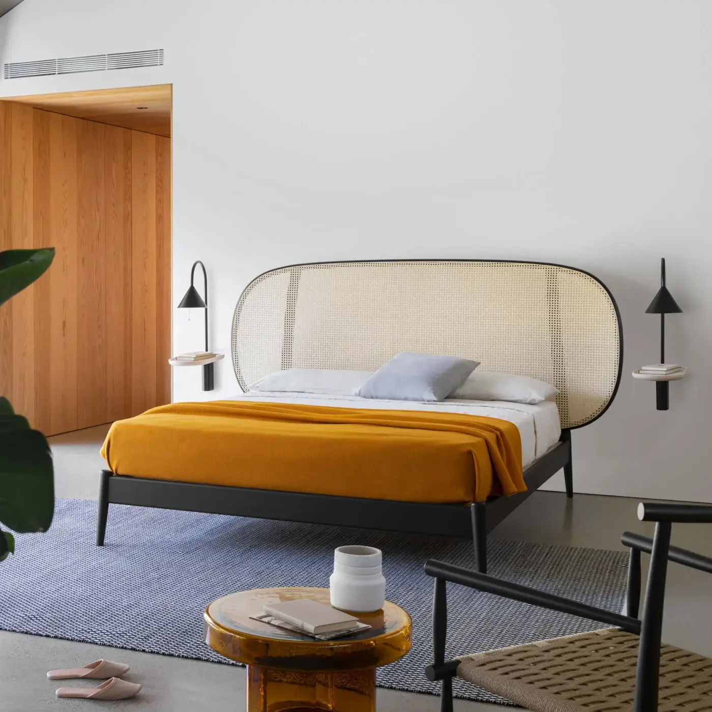 Elegant Miniforms Shiko Wien bed crafted with wood and woven cane, featuring a matte black finish and rounded headboard