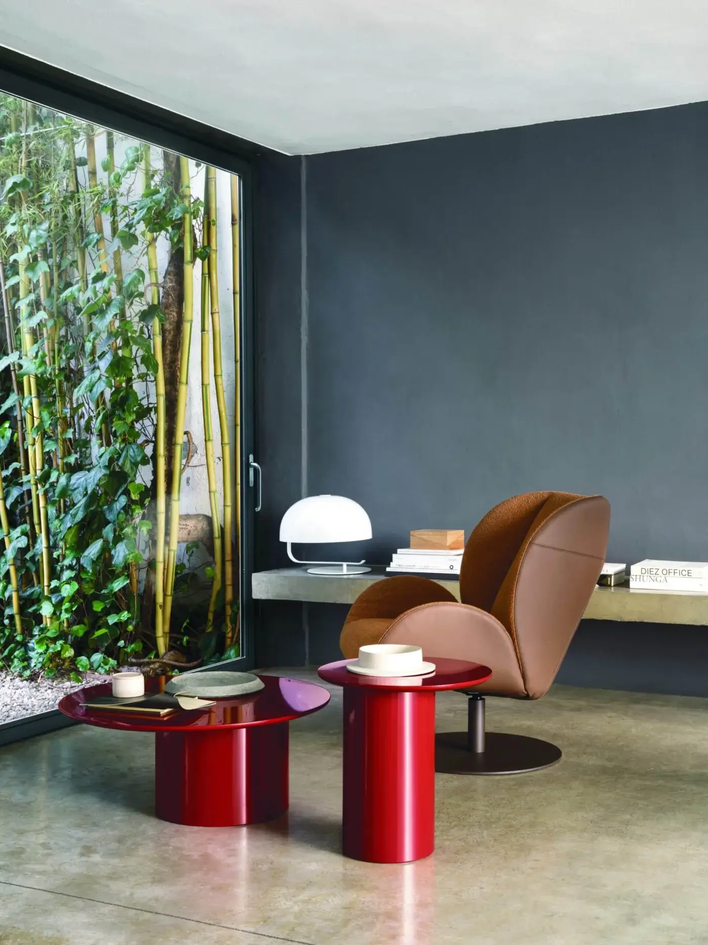 Elegant Frag Ocean lounge chair with a swivel steel base, warm brown leather and tan fabric upholstery