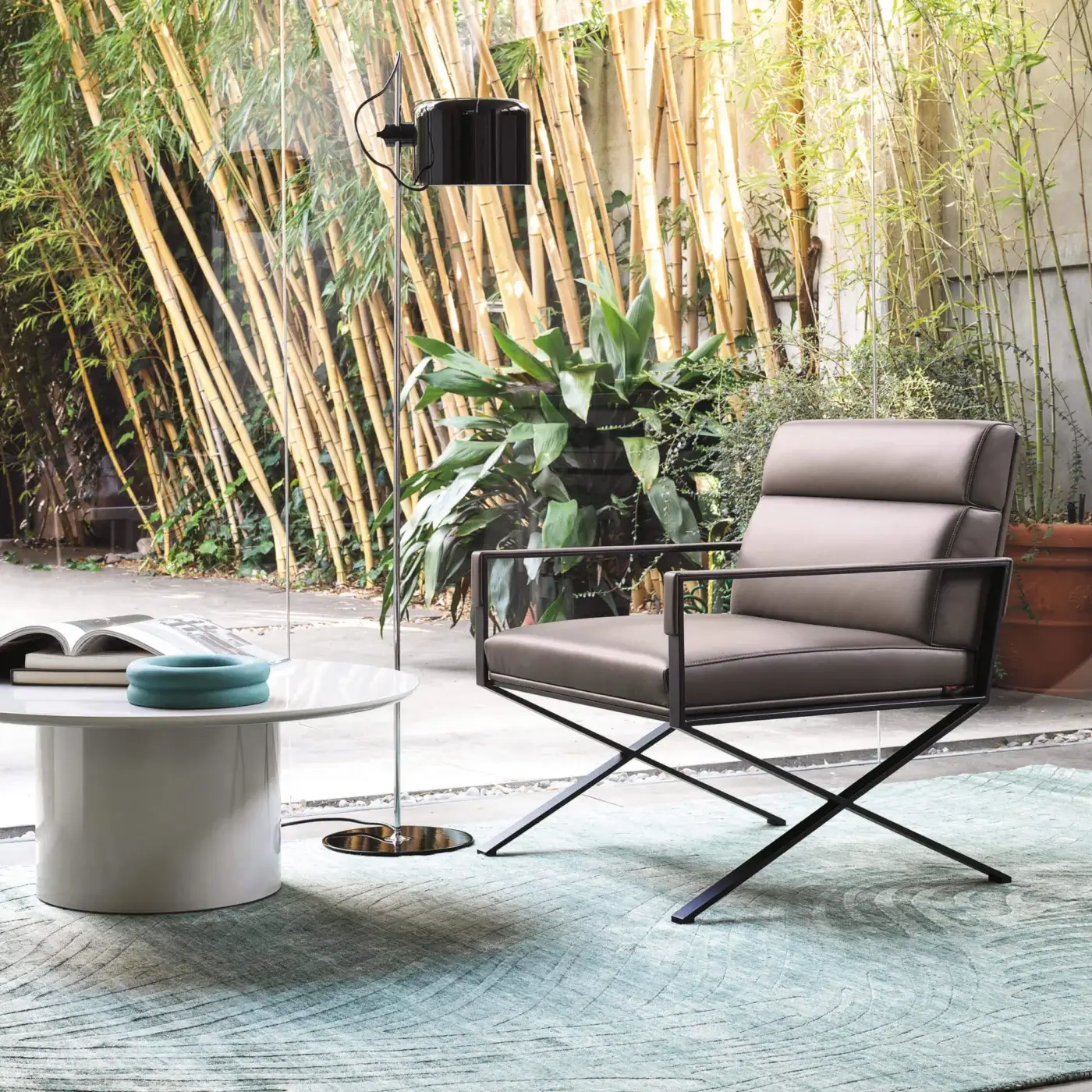 Elegant Frag Sahrai lounge chair in medium gray-brown textile with a matte metal horizontally flipped base
