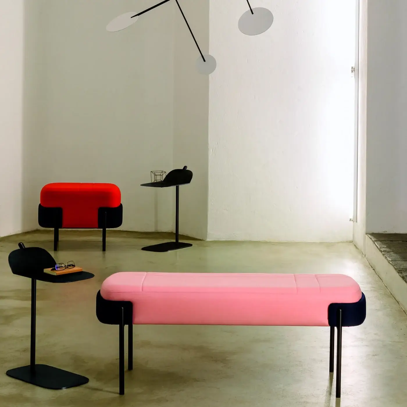 Distinguished Bross Wam bench with pink fabric upholstery and a smooth black metal frame crafted in Italy