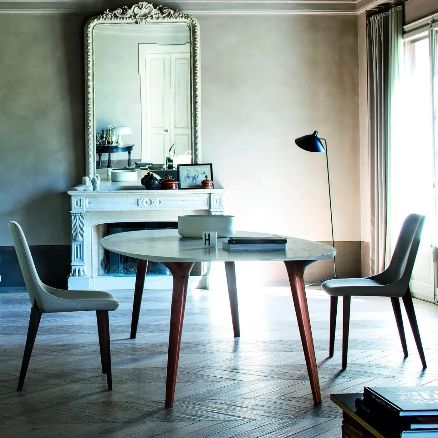 Distinguished Bross Ademar table with ellipsoidal plan in luxury marble and dark brown solid oak legs crafted with a continuous design