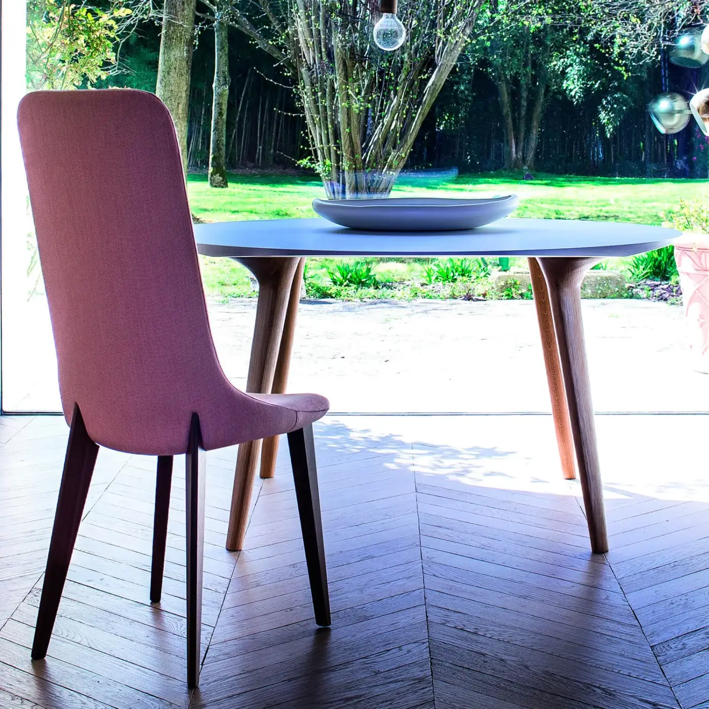 Elegant Bross Ascot chair with light pink premium fabric upholstery and light brown oakwood legs crafted with a natural finish