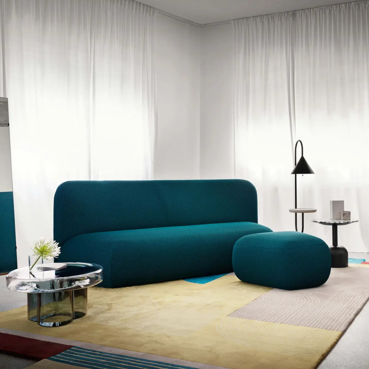 Exclusive Miniforms Botera sofa, a modular seating system upholstered in dark teal textured textile with curved silhouette