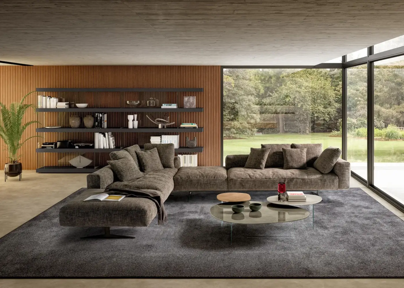 Gray fabric sectional sofa with metal legs, chaise lounge, and gray pillows in a modern living room with wood shelving and concrete ceiling.