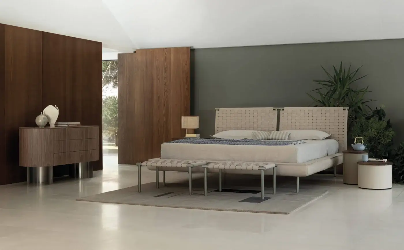 Cierre 1972 platform bed with woven light beige headboard, gray throw, benches, wood dresser, olive green walls, and neutral rug.