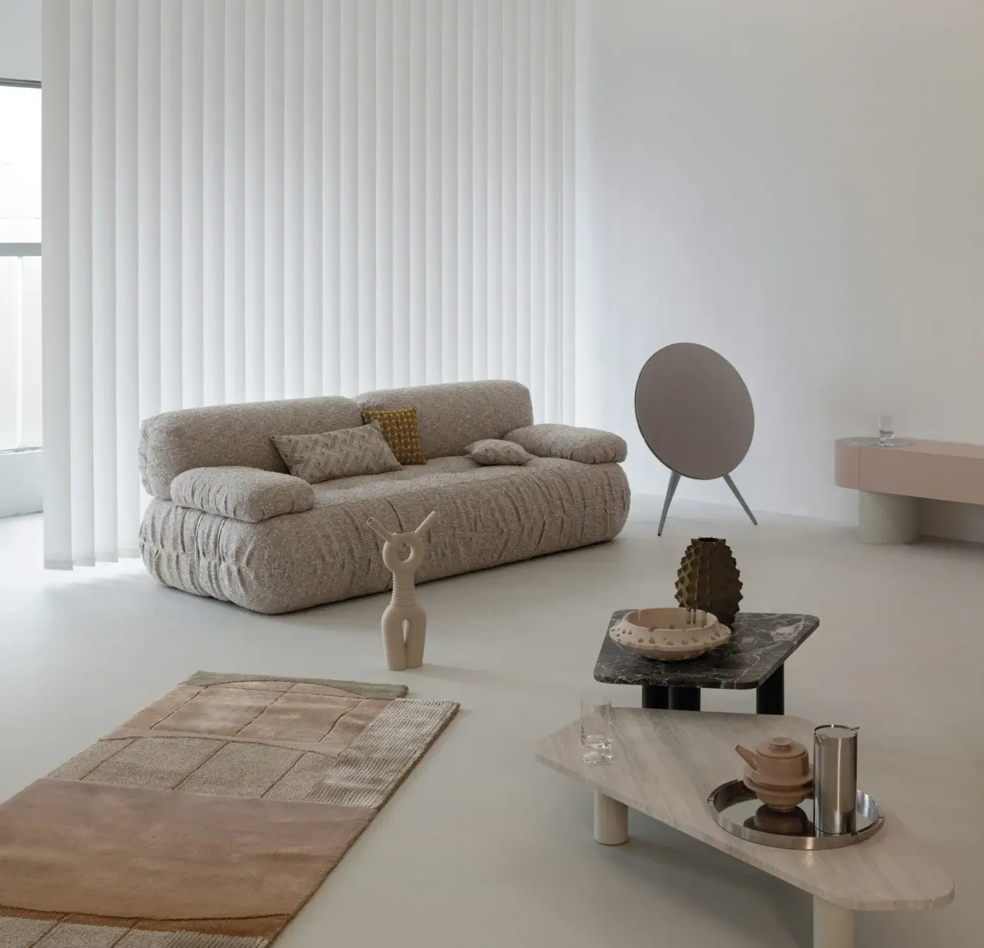 Cierre 1972 sofa, light grey fabric, modular design with rounded cushions, set in minimalist room with rug and accent chair.