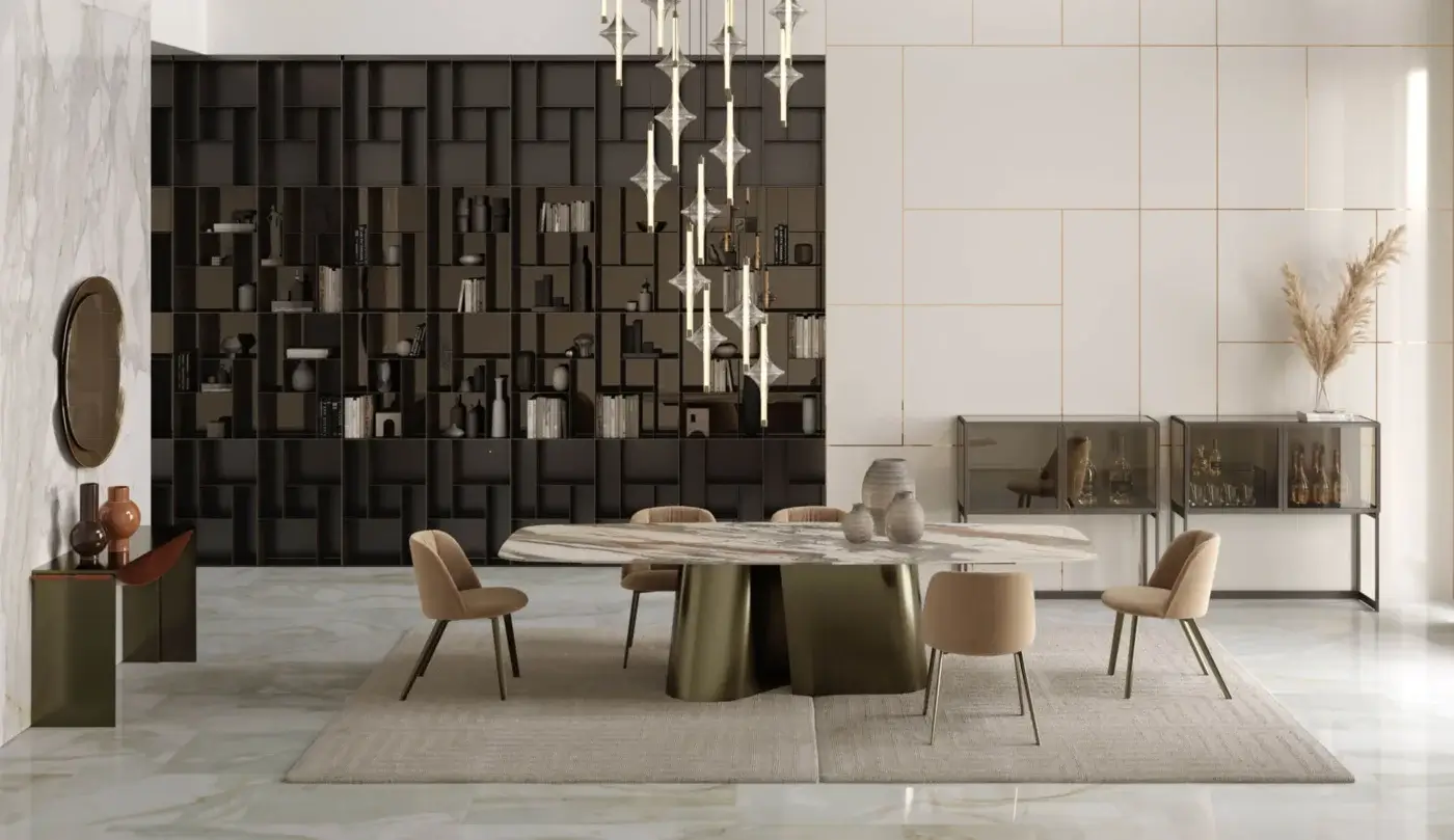 Extendable dining table with white marble top and olive-green swirling base, surrounded by eight beige chairs on a jute rug.