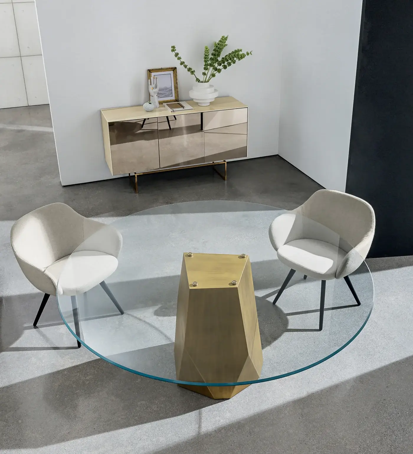 Glass dining table, brass pedestal, Sovet Italia “gran deod”, paired with cream armchairs, and light beige console table in minimalist interior.