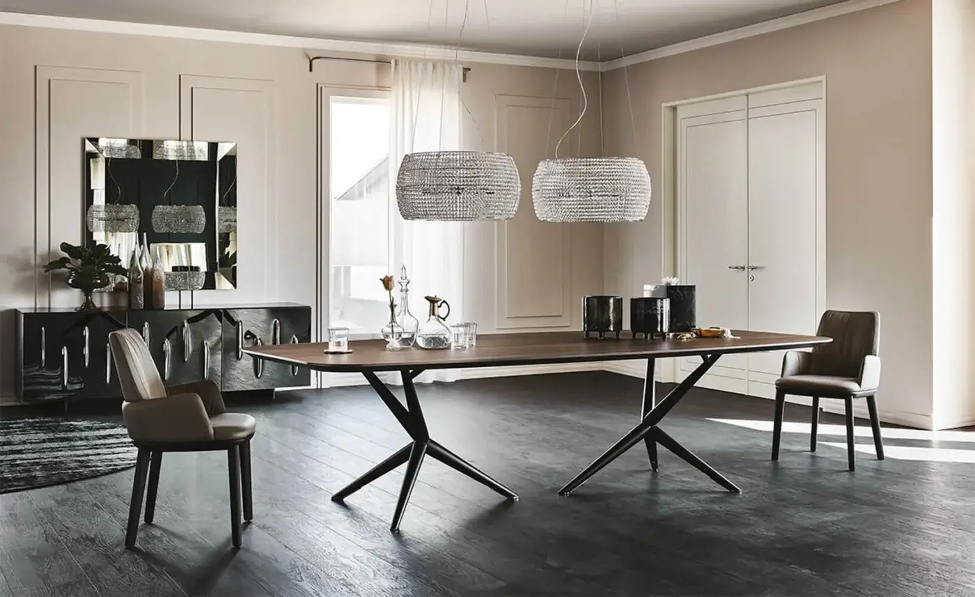 Atlantis dining table, dark wood and polished metal, with angular starburst base and four light brown leather chairs with metal frames.