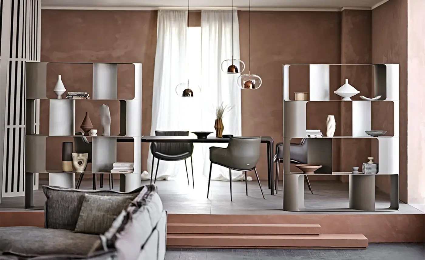Fulham bookcases by Cattelan Italia with gray metal frames and white/gray panels flank a dining area with dark gray table and black chairs.