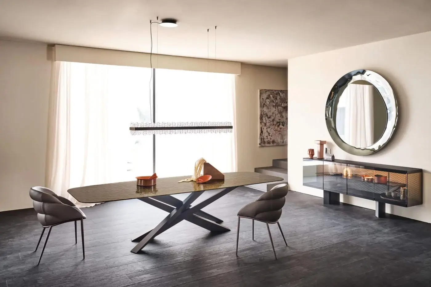 Cattelan Italia Lancer table, dark grey glass top, X-leg base, paired with grey chairs, sideboard, mirror, and chandelier in a dining room setting.