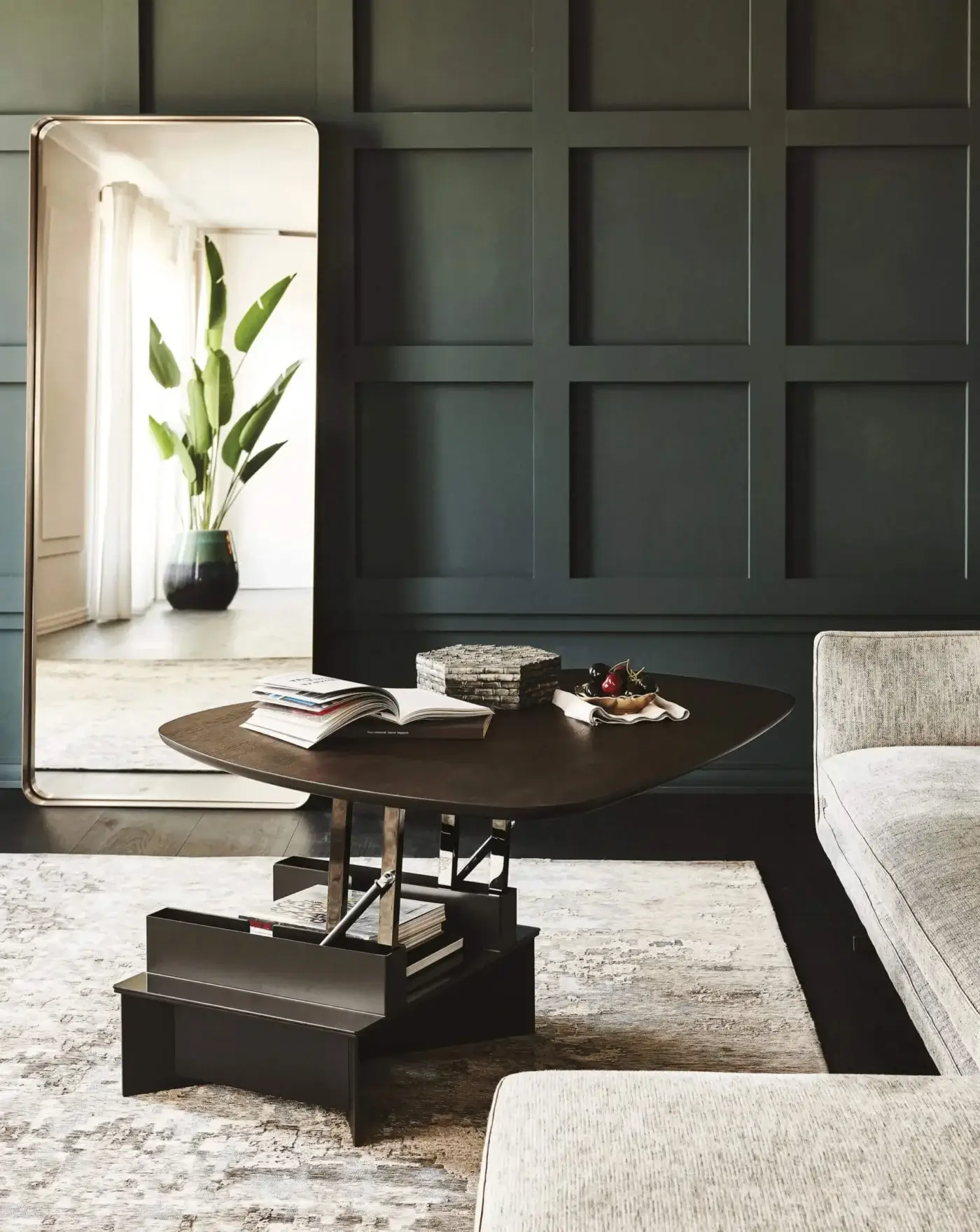 Cattelan Italia Orlando coffee table, dark wood rounded top, black metal lift base with storage, modern gray interior setting.