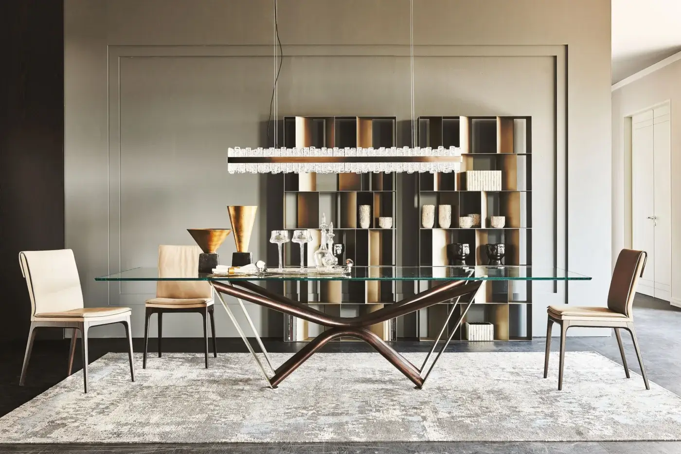 Cattelan Italia Marathon table, clear glass top, dark brown wood starburst base with silver legs, surrounded by beige and brown chairs.