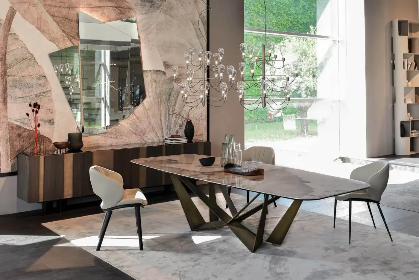 Skorpio Keramik table, marbled ceramic top, flared dark metal base, with beige chairs, wood sideboard, glass chandelier, gray rug, modern dining room.