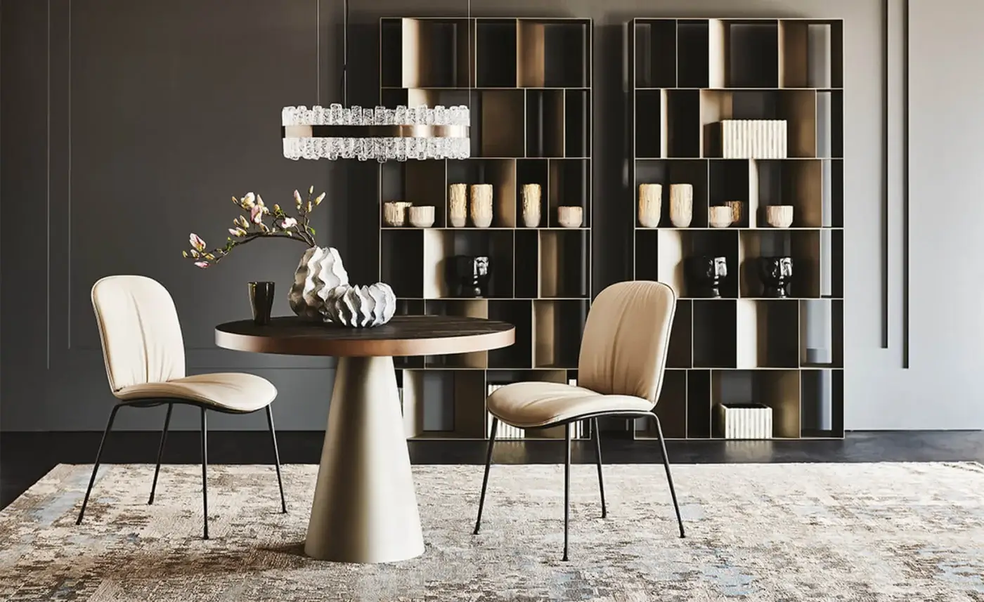 Cattelan Italia Saturno Keramik bistrot table with dark brown top, beige conical base, and two light beige upholstered chairs in a gray dining room.