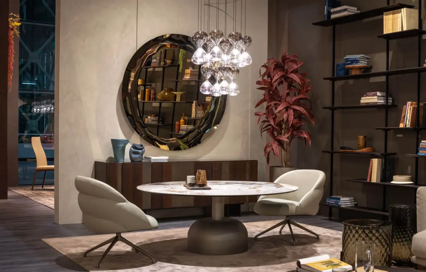 Round dining table with marble top and two Camilla lounge chairs, featuring star-shaped metal bases, in a contemporary dining room setting.