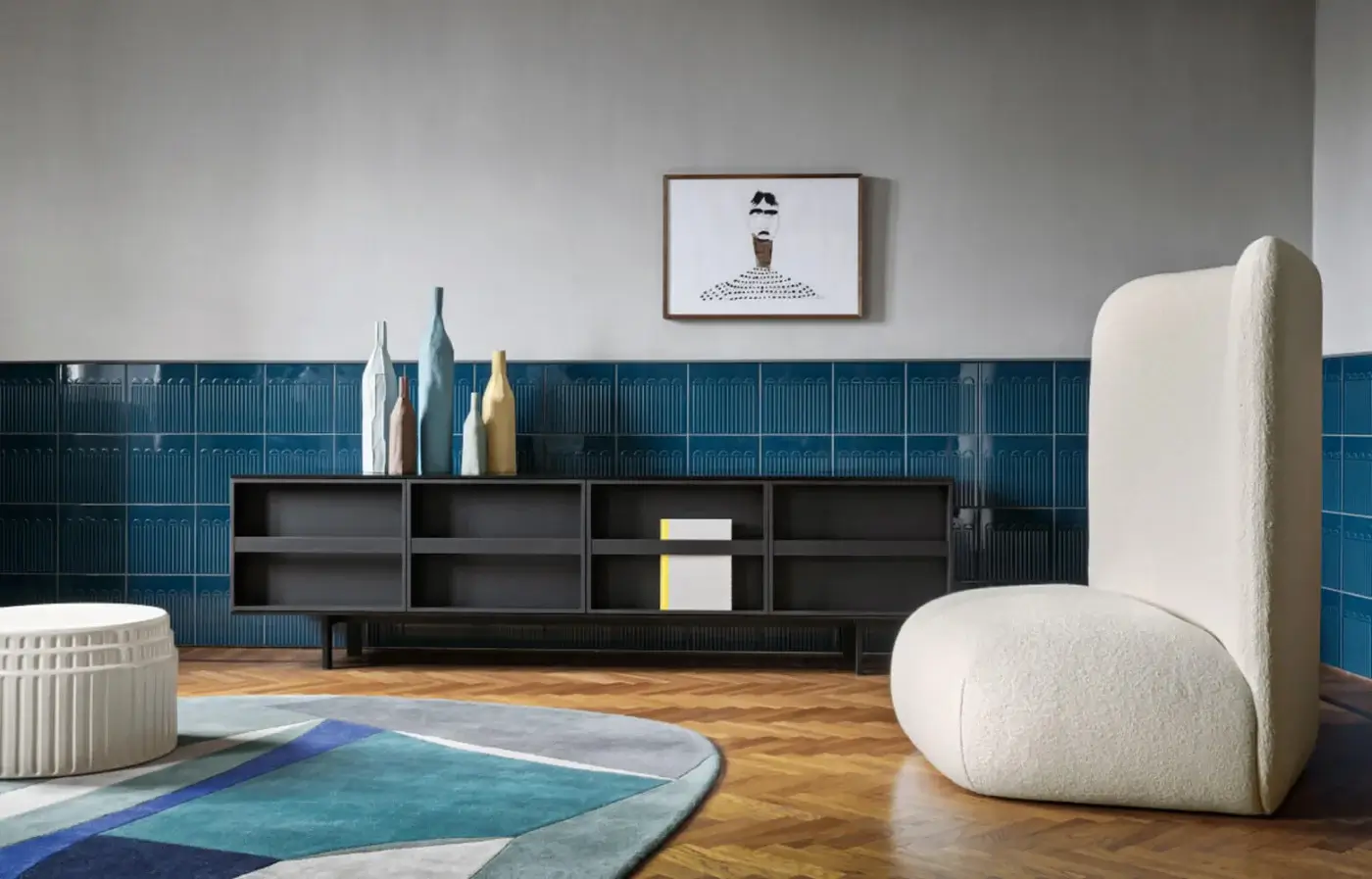 Ramblas sideboard, dark gray metal frame, three open turquoise vase displays, paired with cream boucle armchair and abstract rug.