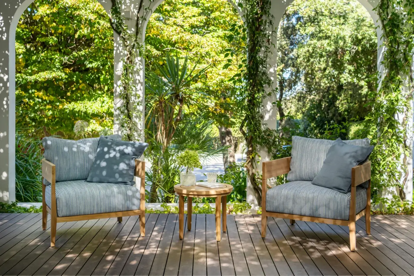 Fine Braid Feeling lounge chair with honey-brown teak frame and white striped textile cushions plus muted blue-grey pillow