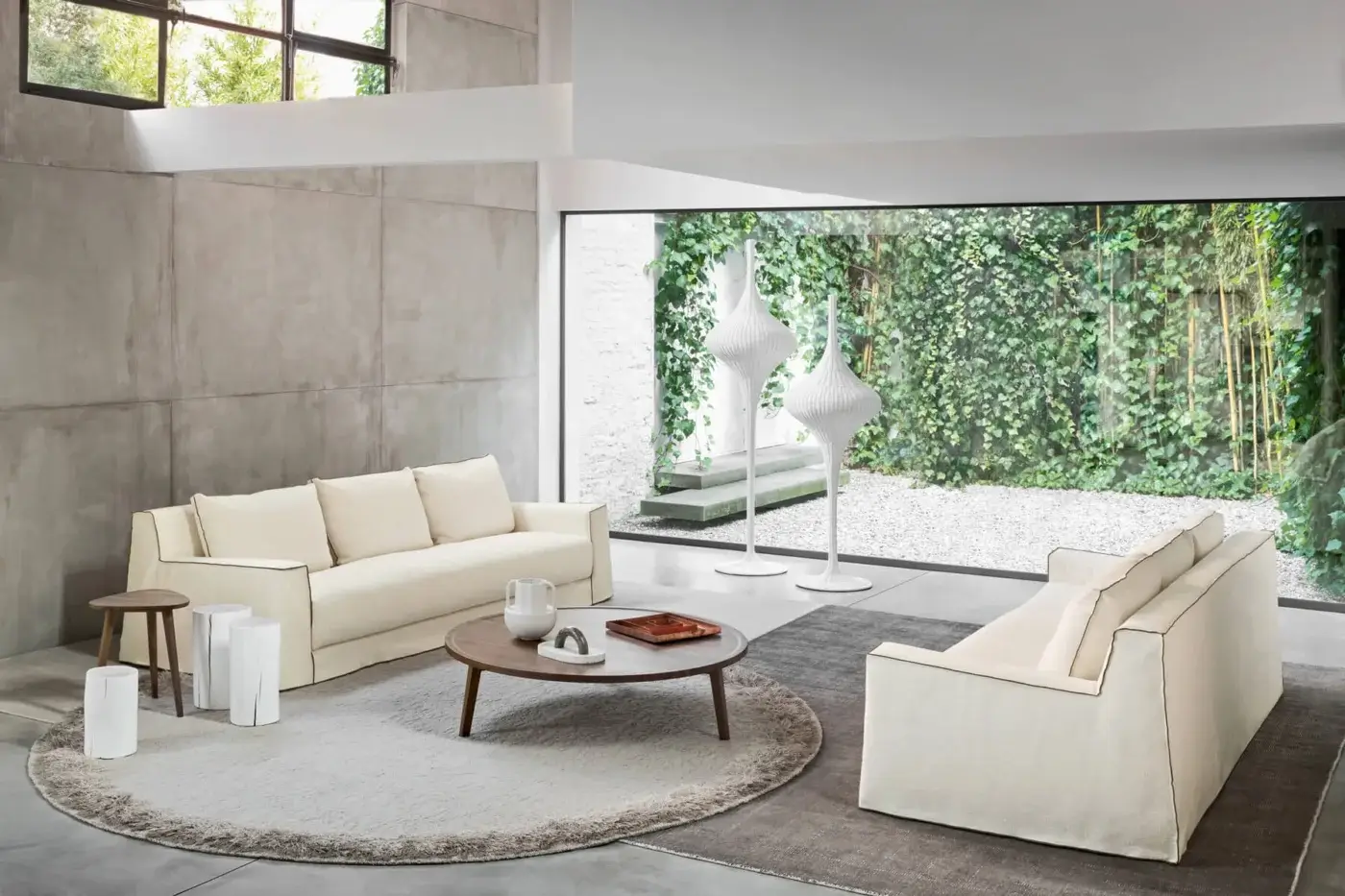 Elite Gervasoni Loll sofa with cream or off‑white removable cover, dark piping trim, goose down cushions, silhouette.