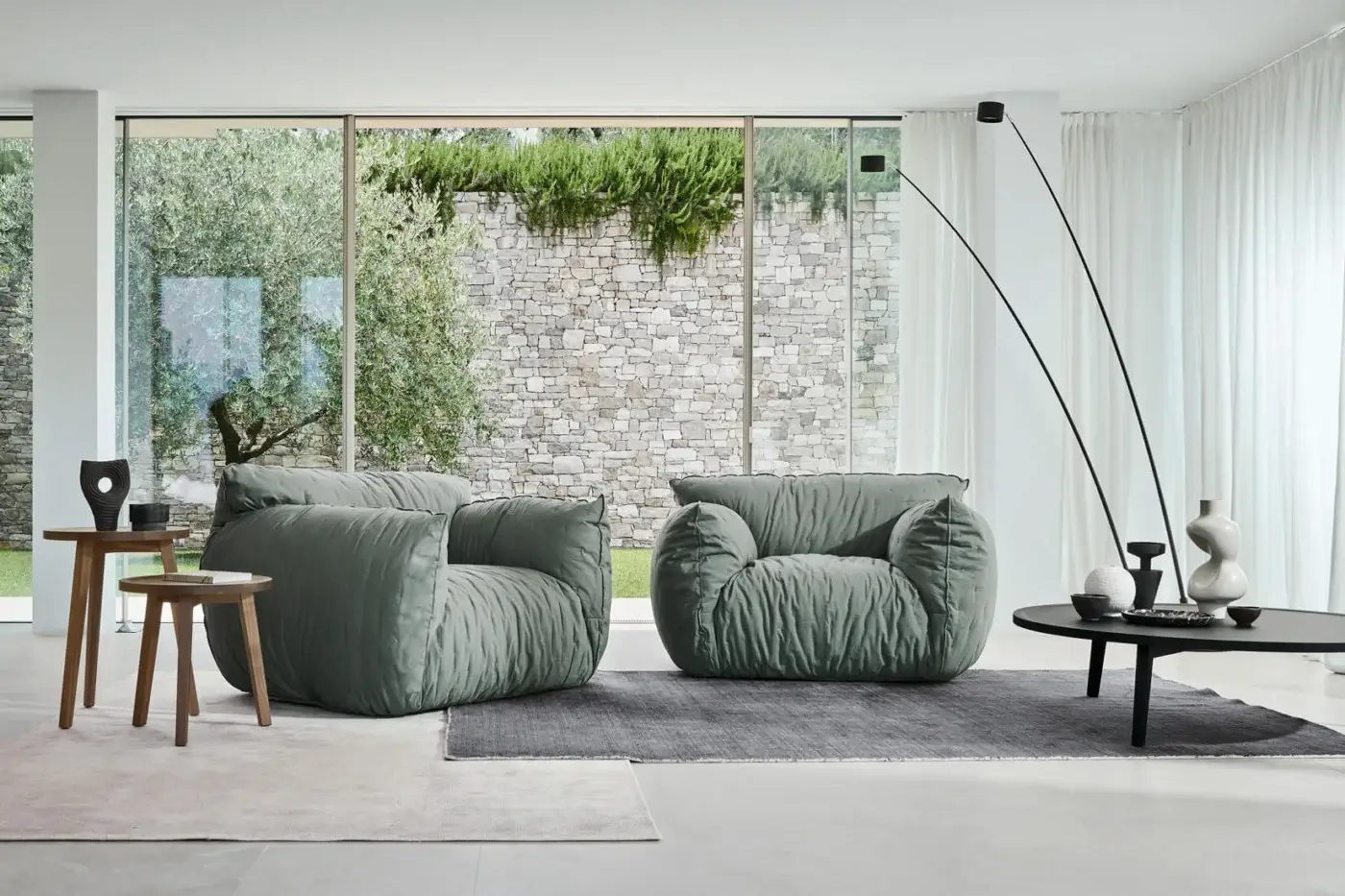 Sumptuous Gervasoni Nuvola lounge chair in muted sage green textile with matte textured finish and organic silhouette