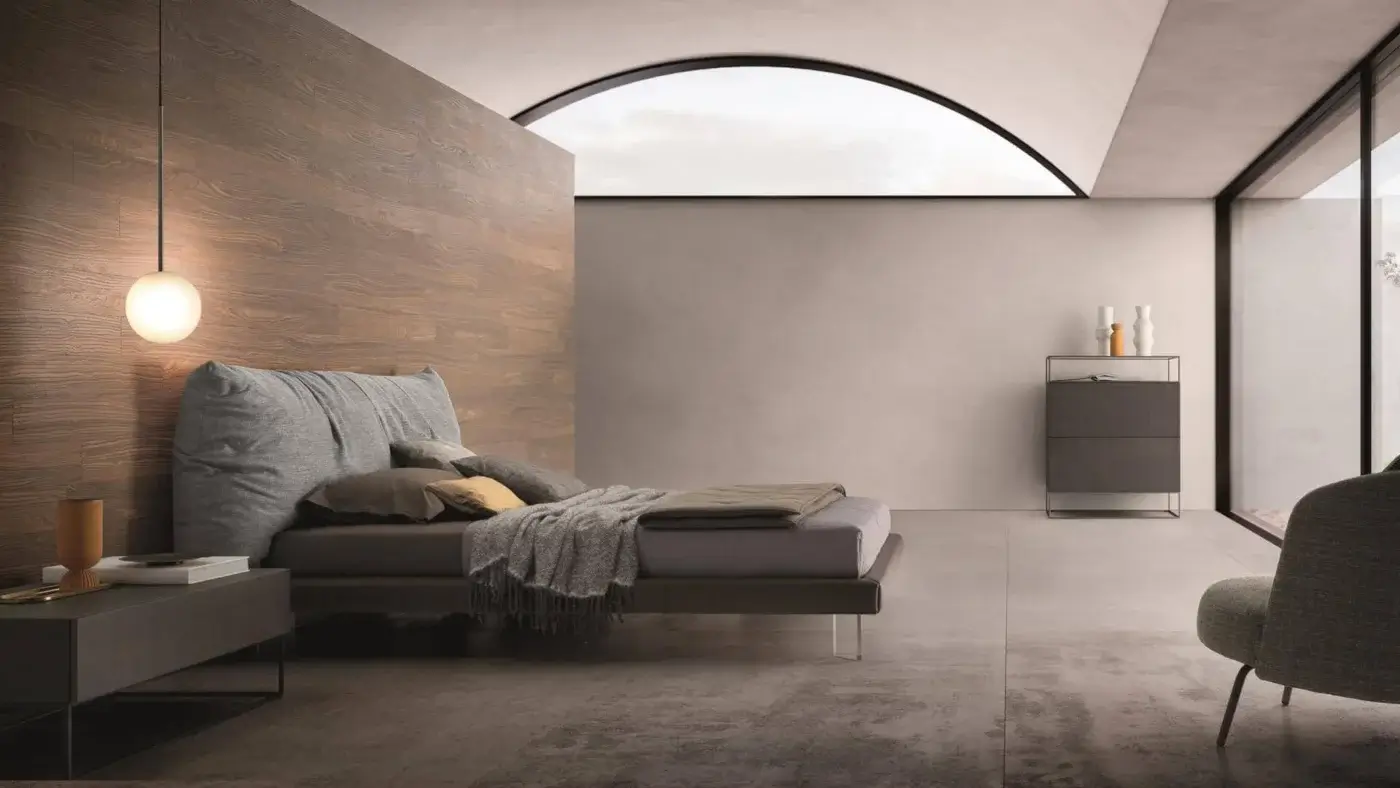 Superior Ditre Italia Papilo bed with plush light gray textile and transparent legs, adorned with brown and gold pillows